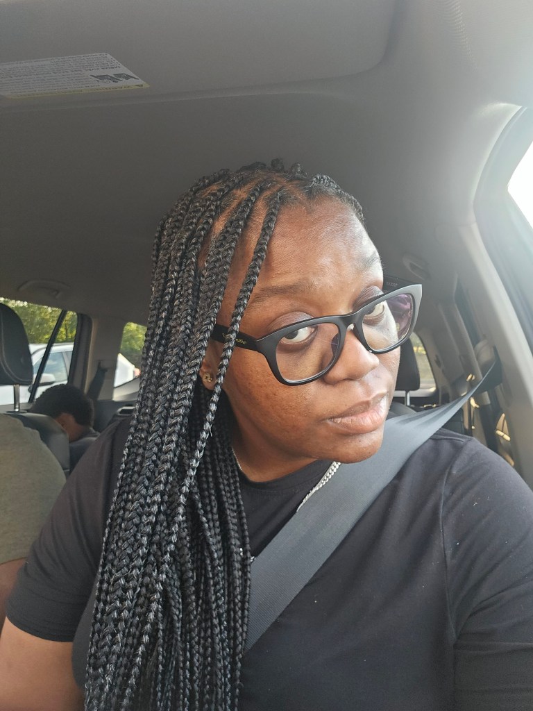 me sitting in a car with medium box braids.